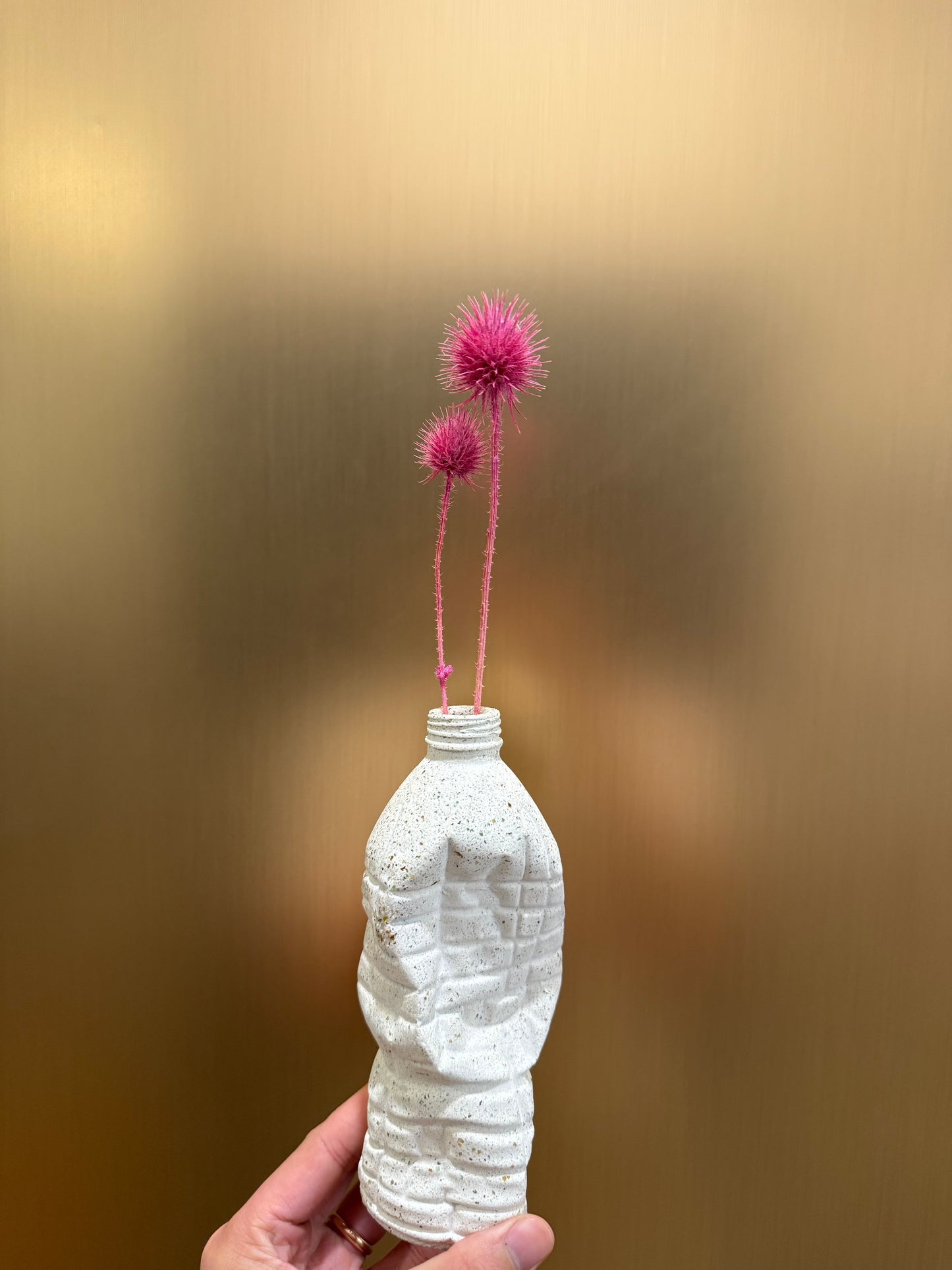 Crashed white bottle with pink spiked thistle